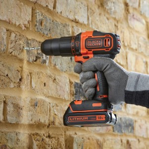 Black+Decker Akku-Schlagbohrschrauber beim Bohren in eine Ziegelwand.