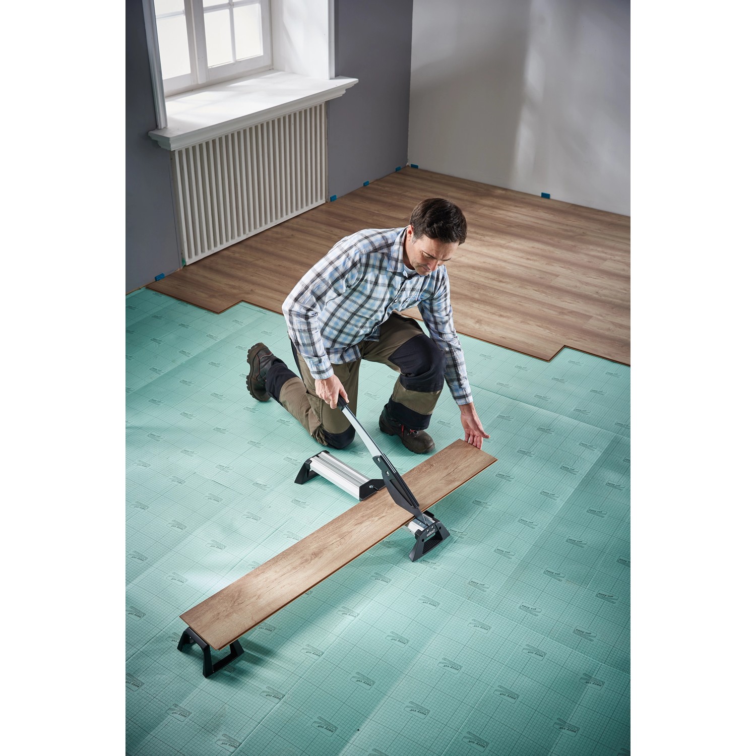 Mann schneidet Laminat mit wolfcraft Vinyl- und Laminatschneider VLC 800.