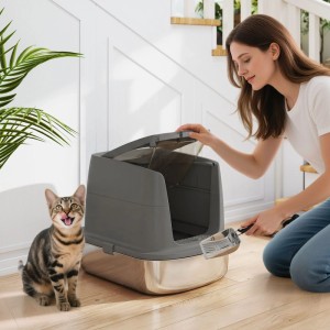 Dunkelgraue PawHut Katzentoilette mit Edelstahlwanne. Frau reinigt mit Schaufel, Katze davor. Für saubere Katzenklos.