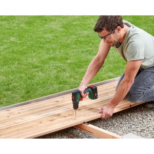 Mann schraubt mit Bosch 18V Akku-Schlagbohrschrauber Universalimpact 18V-60 Solo eine Holzterrasse.