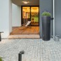 4rain AZURA Regentonne in Graphitgrau mit Pflanzschale und Auslaufhahn vor modernem Haus.