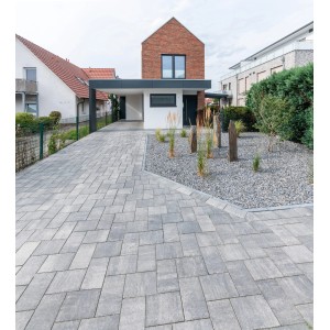 Diephaus Pflastersteine Mika Quarzit, 30x20x6 cm, verlegt als Hofeinfahrt vor einem Wohnhaus.
