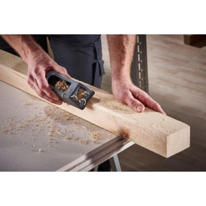 Hände hobeln Holz mit wolfcraft Blockhobel 150x57mm. Schwarzer Kunststoffhobel für Gipskarton & Holzbearbeitung.