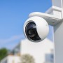 Weiße Ezviz HB8 2K Akku-Kamera mit 4 MP, montiert an einem Pfosten vor blauem Himmel.