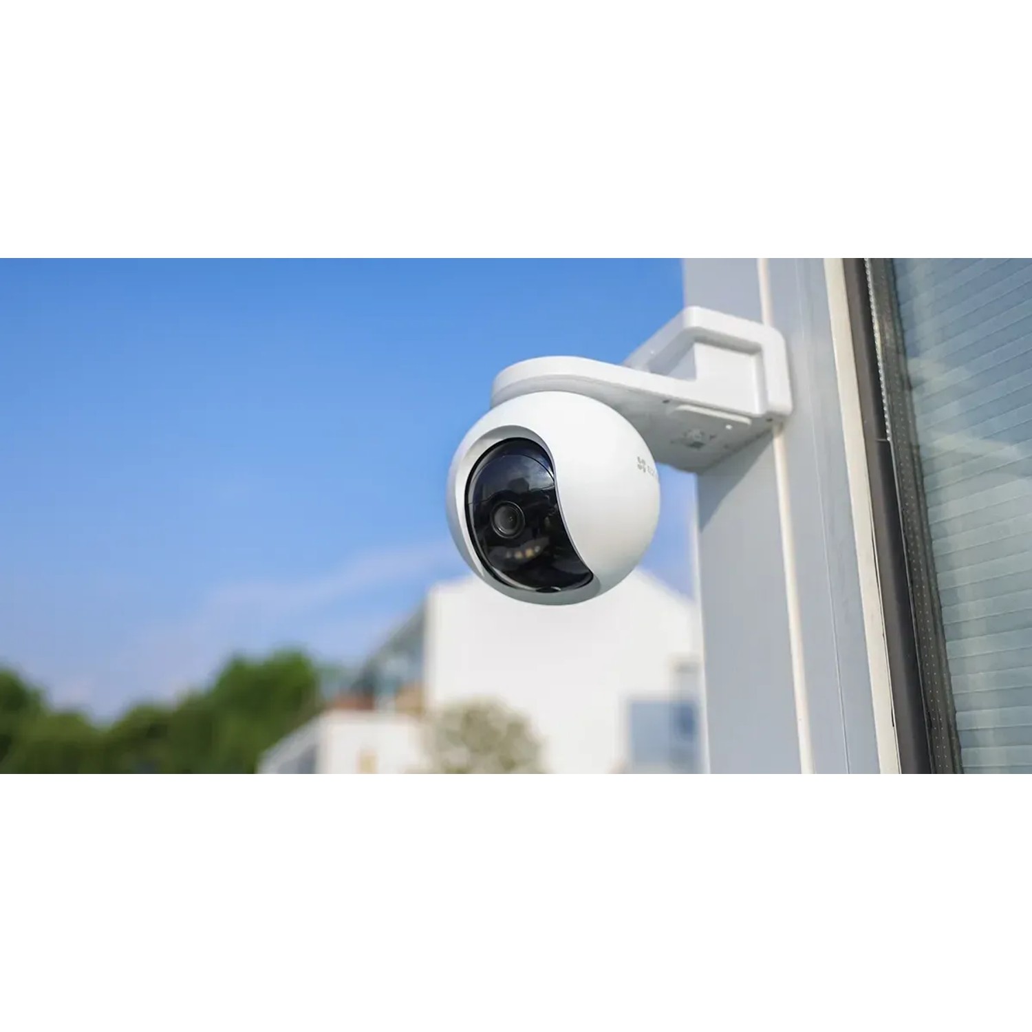 Weiße Ezviz HB8 2K Akku-Kamera mit 4 MP, montiert an einem Pfosten vor blauem Himmel.