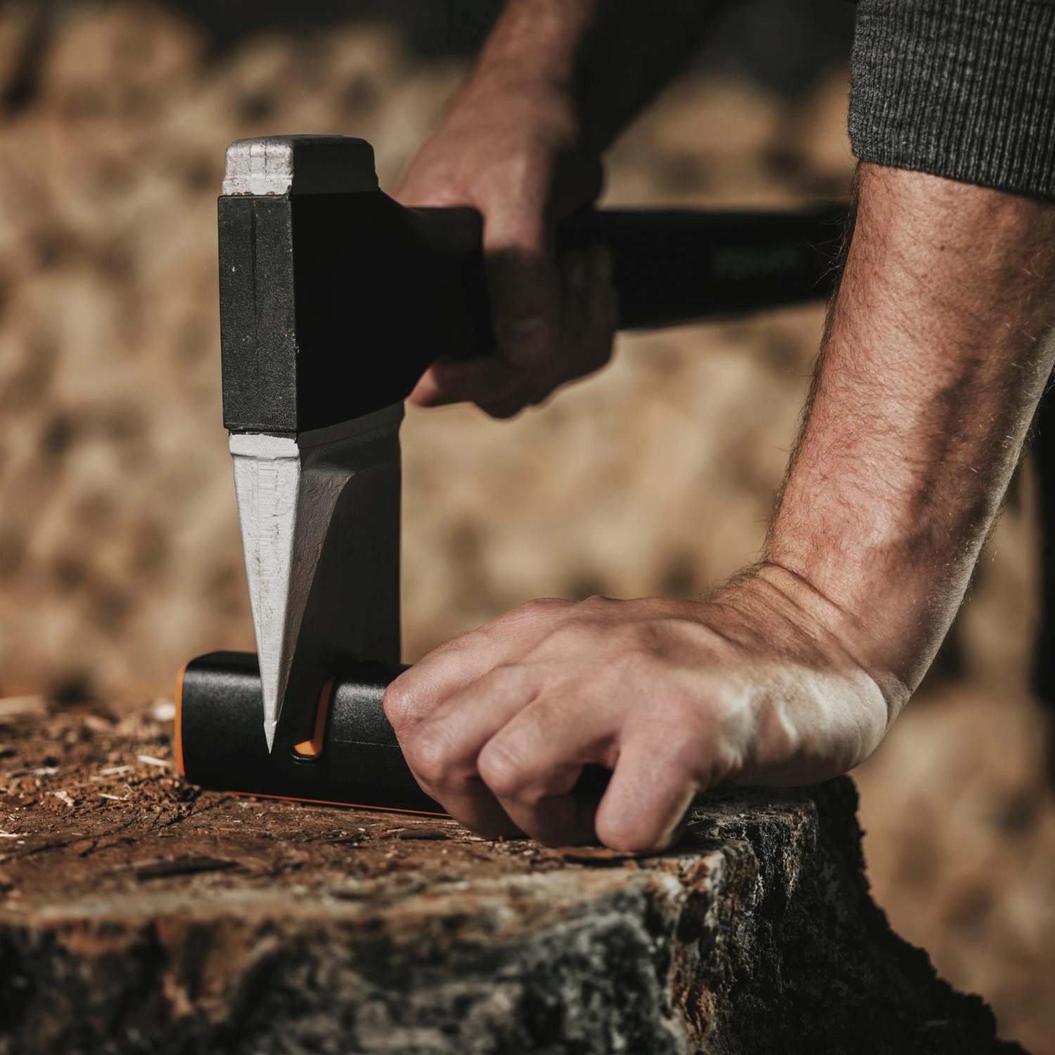 Fiskars Axt schärfen mit dem Xsharp Messerschärfer auf einem Holzstamm.