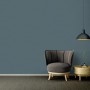 Blaue, leicht strukturierte Vliestapete Uni Matt von OBI im Raum mit Sessel und Lampe.