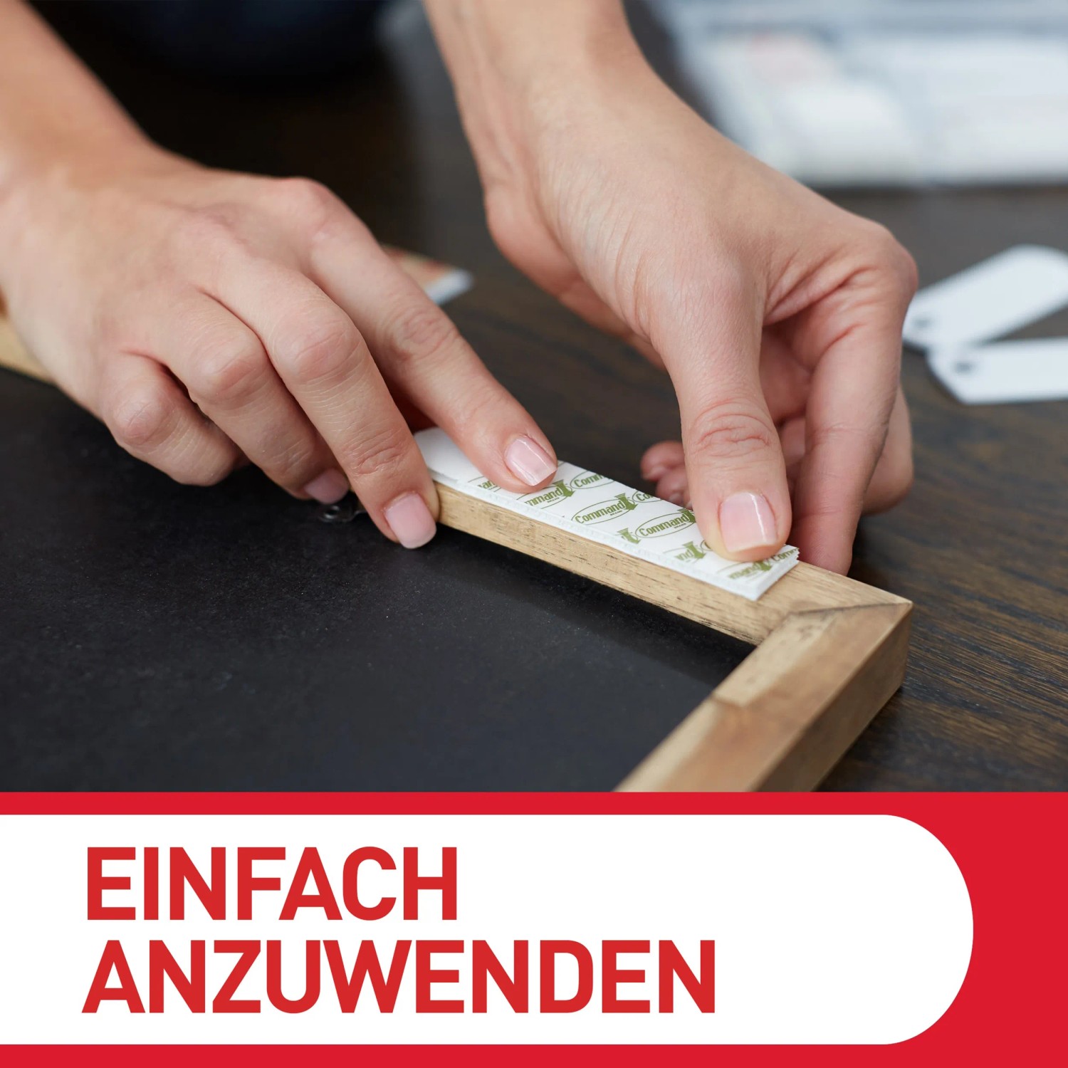 Anbringen eines Command Bilder-Montage-Strips am Rahmen.