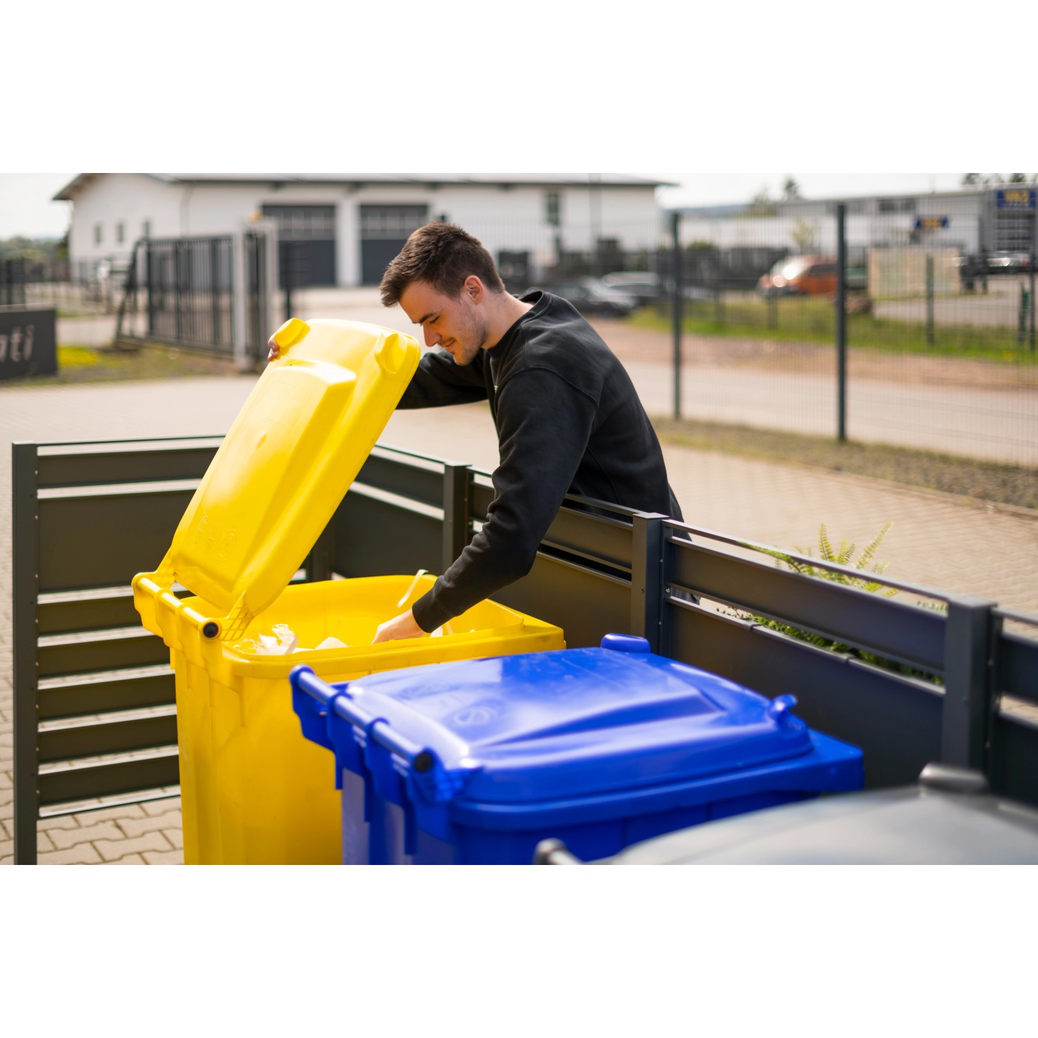 Westmann Mülltonnenverkleidung Planum Metall Holzoptik mit Mülltonnen in Gelb und Blau.