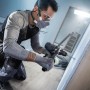 Handwerker bohrt mit Bosch Expert Universalbohrer CYL-9 ein Loch in die Wand.
