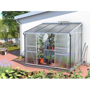 Anlehn-Gewächshaus Ida 5200 mit Alu-Rahmen und Pflanzen auf Regalen vor einer Hauswand.