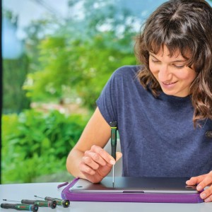 Frau nutzt Präzisions-Schraubendreher aus dem 13-teiligen Set für Laptop-Reparatur. Ergonomischer Griff, ideal für feine DIY-Arbeiten.