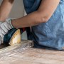 Handwerker schleift Holz mit Bosch Exzenterschleifer und Schleifblatt C470 K80.