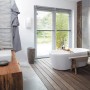 Clage Durchlauferhitzer DCX Next L im modernen Bad mit Wanne und Holzelementen.