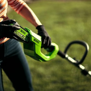 Greenworks Akku-Rasentrimmer G40LTK2: Bediener mit Akku beim Rasentrimmen.
