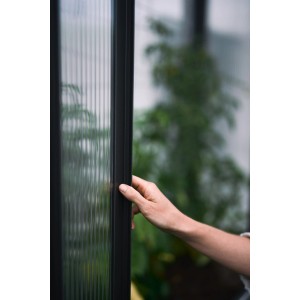 Hand berührt geripptes, lichtdurchlässiges Panel des Biohort Gewächshaus Florentina in Dunkelgrau-Metallic.