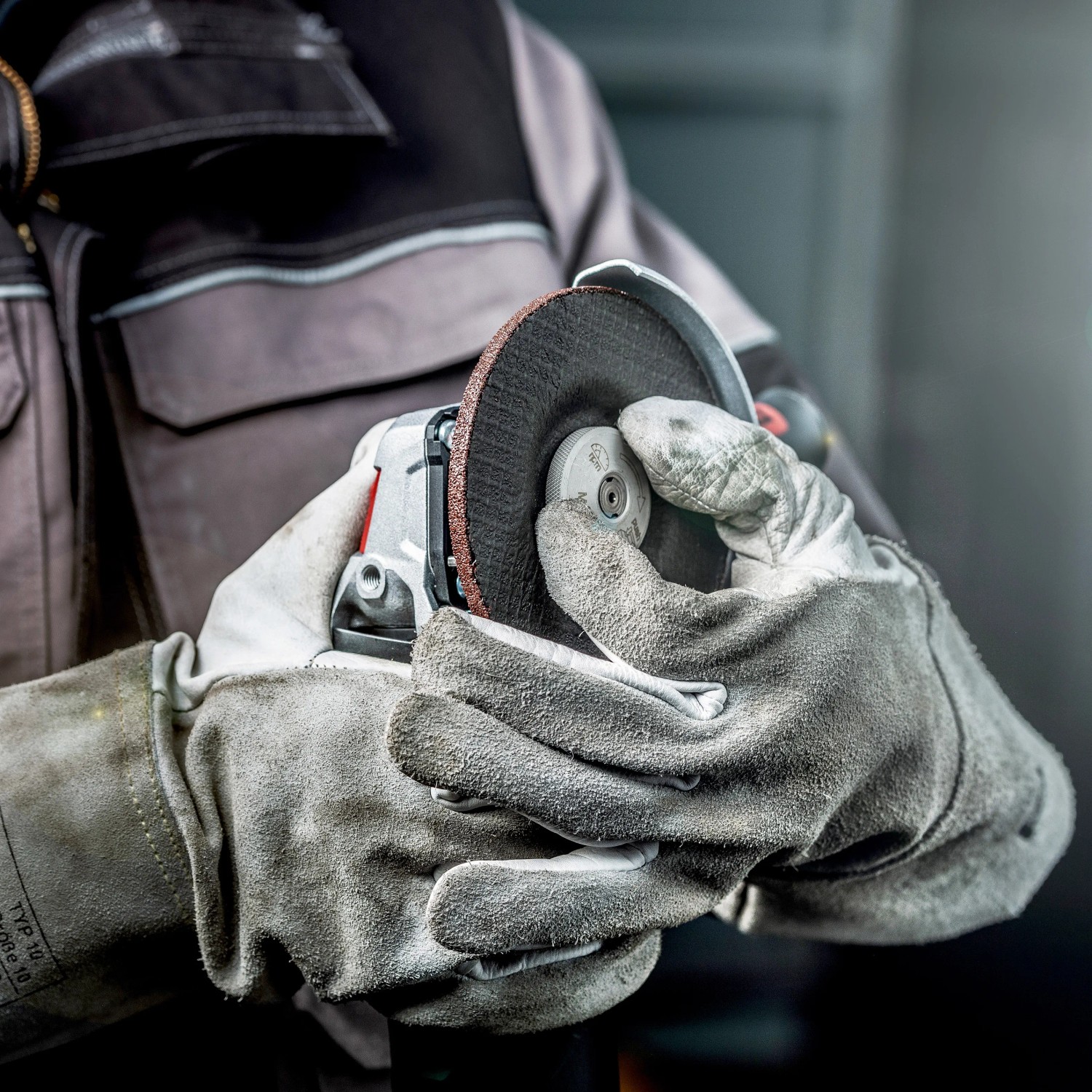 Metabo Winkelschleifer WEV 11-125 Quick mit Trennscheibe in Händen einer Person mit Arbeitshandschuhen.