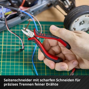 Hand schneidet Kupferdraht mit rotem Einhell Seitenschneider. Präzises Werkzeug aus dem Feinmechaniker-Zangen Set für Elektronik & Modellbau.