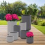 Verschiedene graue Fiberstone Pflanzgefäße mit strukturierter Oberfläche im Garten.