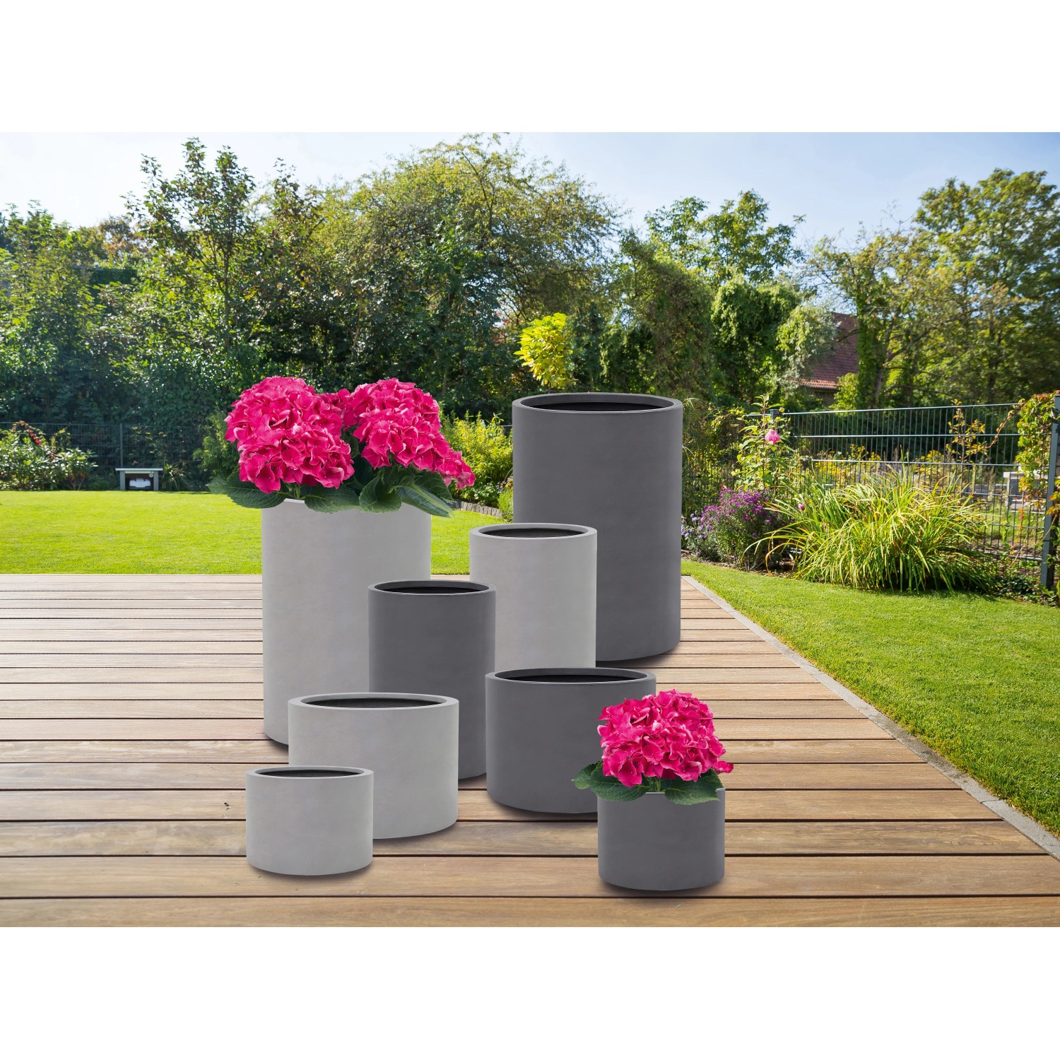 Verschiedene graue Fiberstone Pflanzgefäße mit strukturierter Oberfläche im Garten.