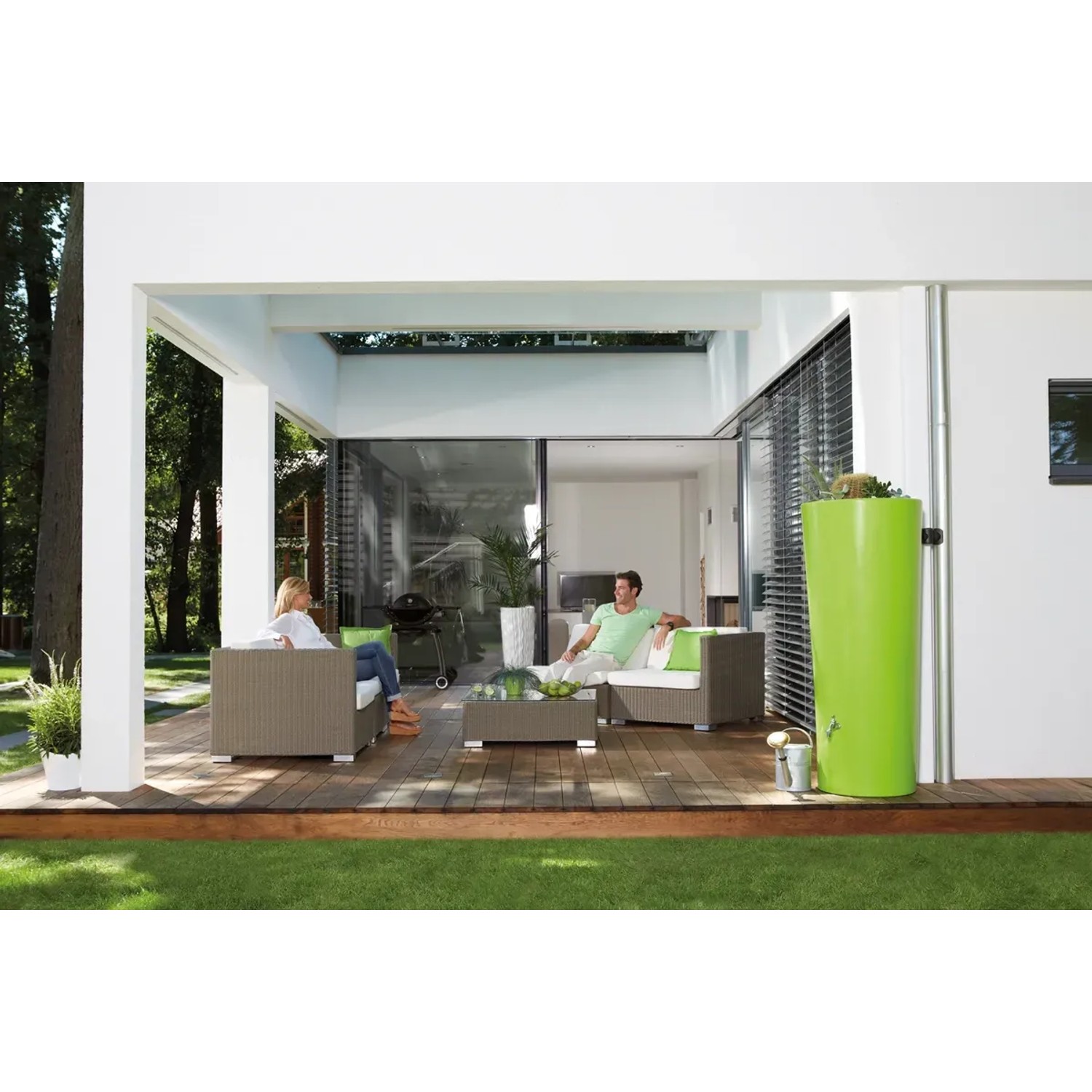 Garantia Regenwasser-Behälter 2in1 Color 350 l Apple im Garten mit Lounge-Möbeln.