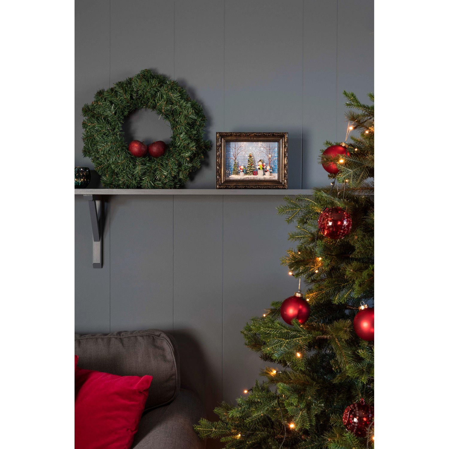 Konstsmide LED-Bilderrahmen mit Schneemännern auf Regal neben Weihnachtsbaum.
