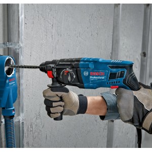 Bosch Professional GBH 2-21 Bohrhammer im Einsatz mit Staubabsaugung an einer Wand.