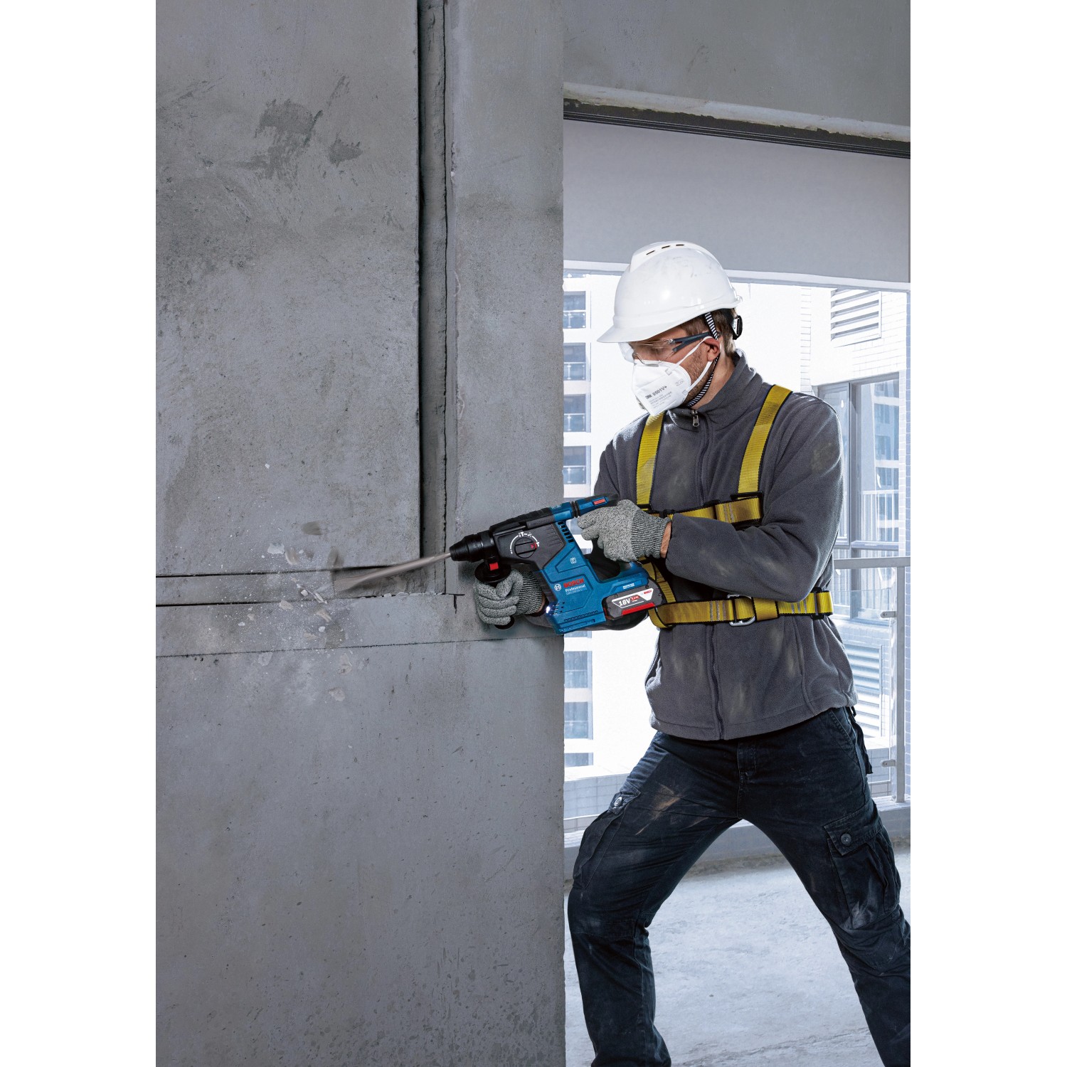 Bosch Professional Akku-Bohrhammer GBH 18V-24 C beim Bohren in Betonwand.