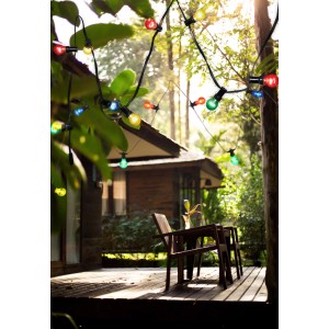 Globo Solar-LED-Lichterkette mit bunten Glühbirnen auf einer Terrasse.