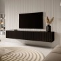 Schwarzes Selsey Veldio TV-Hängeboard mit Lamellenfront, 175 cm, schwebend im modernen Wohnzimmer unter einem Fernseher.