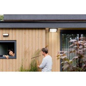 Philips MyGarden Moonshine Deckenleuchte in Anthrazit an Hauswand mit Person.