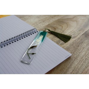 Klarer Epoxidharz-Lesezeichen mit Blume und Quaste auf Notizbuch, ideal für kreative Projekte.