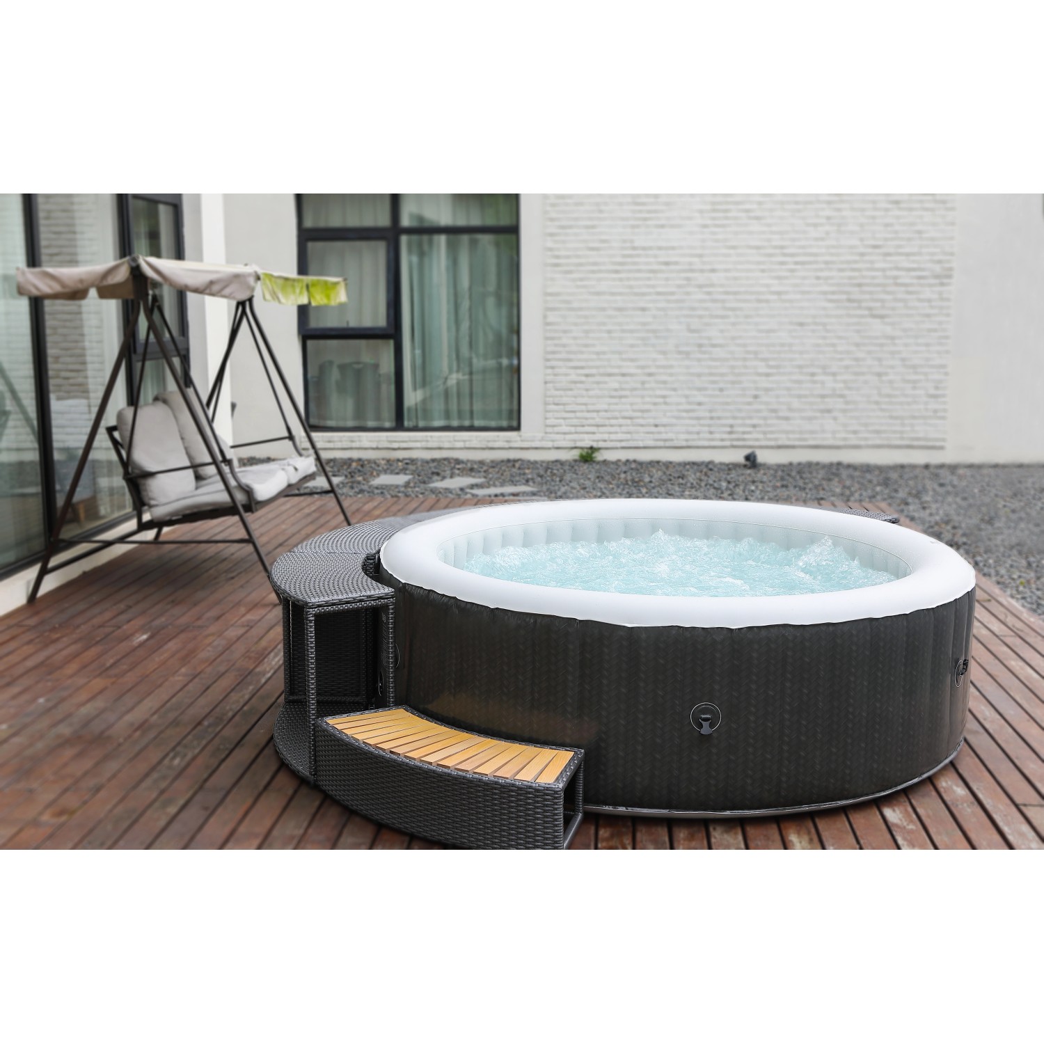 Mobiler, runder OBI Whirlpool im Rattan Design mit Treppe und sprudelndem Wasser.