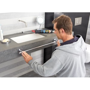 Mann montiert Handtuchhalter mit Pattex Spezialkleber One For All Kristallklar im Bad.