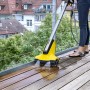 Kärcher PCL 4 Terrassenreiniger in Aktion: Gelber Flächenreiniger säubert Holzterrasse mit Wasser.
