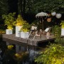 Lechuza Canto Stone Pflanzgefäße mit LED-Lichtband in Quarzweiß auf Holzsteg am Wasser.