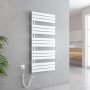 Weißer elektrischer Badheizkörper 60x132cm mit Thermostat und Timer, an grauer Wand im modernen Bad.