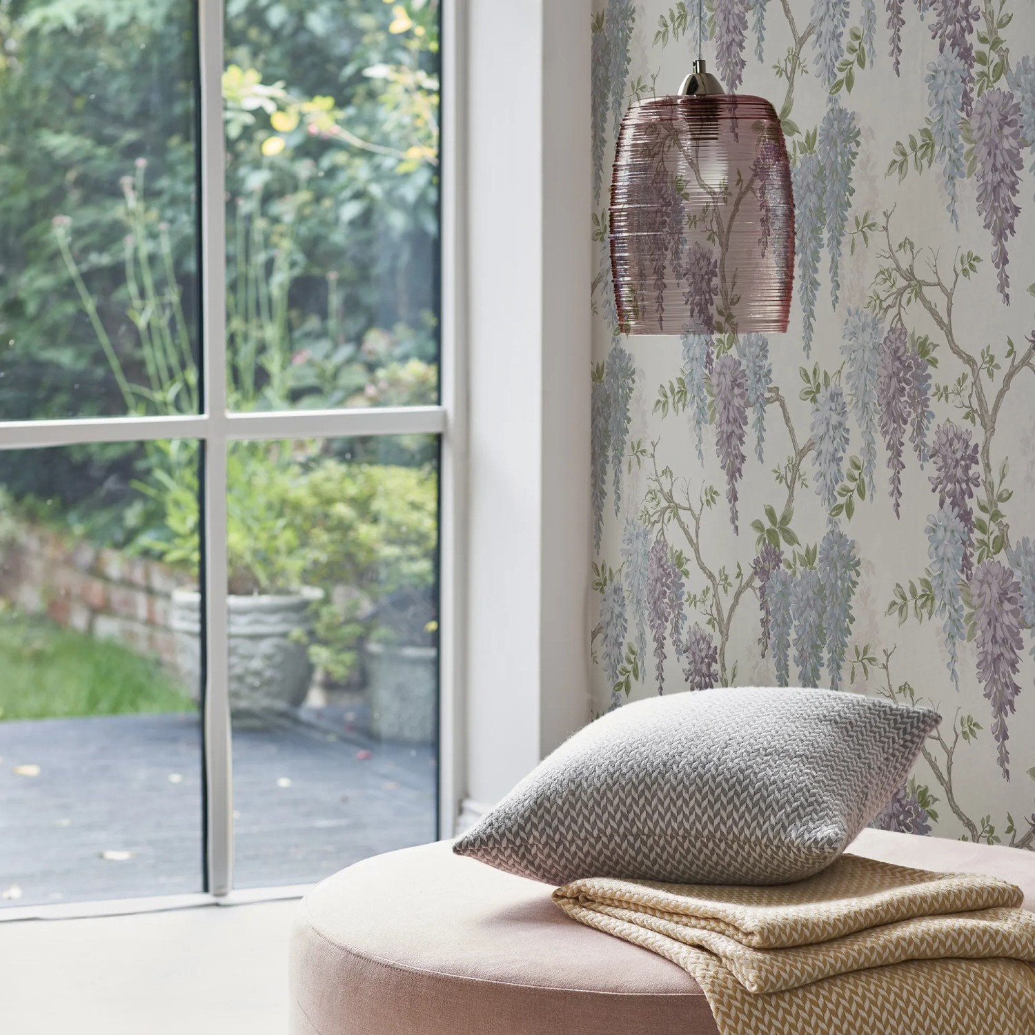 Laura Ashley Vliestapete Wisteria Garden Pale Iris mit zarten Glyzinienblüten im Wohnraum.