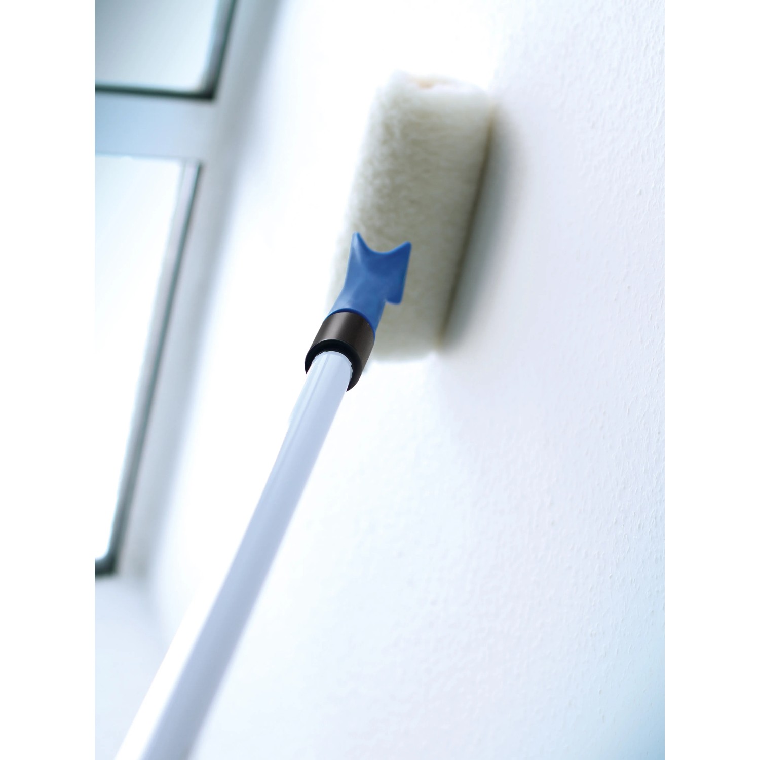LUX Farbroller Kunstfell 25 cm mit Teleskopstange beim Streichen einer Wand.