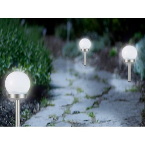 Dekorative Solar-Kugeln mit Erdspieß in Weiß-Silber entlang eines Gartenwegs.