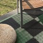 Andiamo Klick-Fliesen Grün/Schwarz (7 Stk.) auf Terrasse mit Stuhl und Hocker.