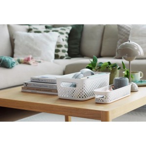 Zwei weiße SmartStore Essence Slim Aufbewahrungskörbe auf einem Tisch im Wohnzimmer.