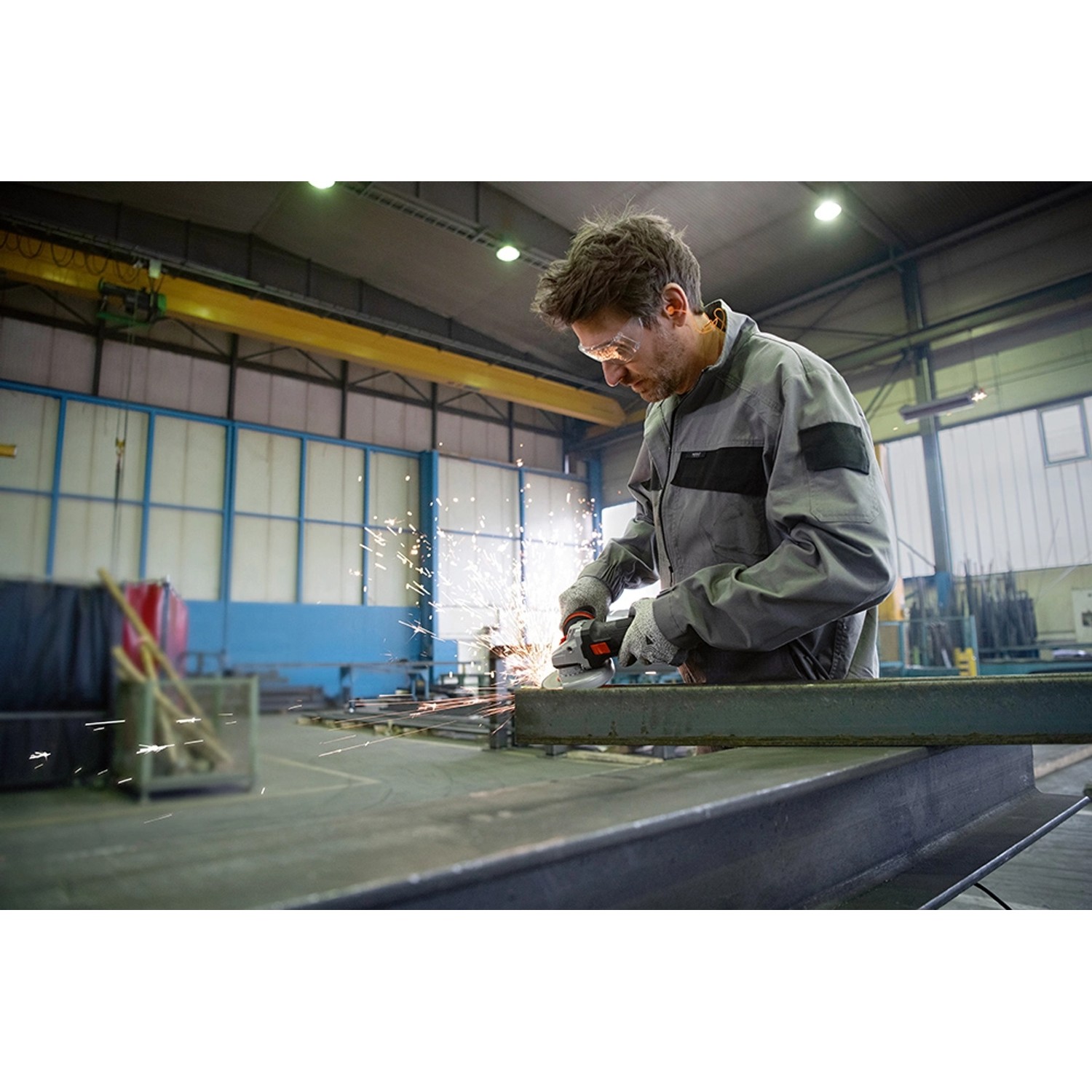 Mann schleift Metall mit dem Bosch Professional GWS 17-125 SB Winkelschleifer, Funken sprühen.