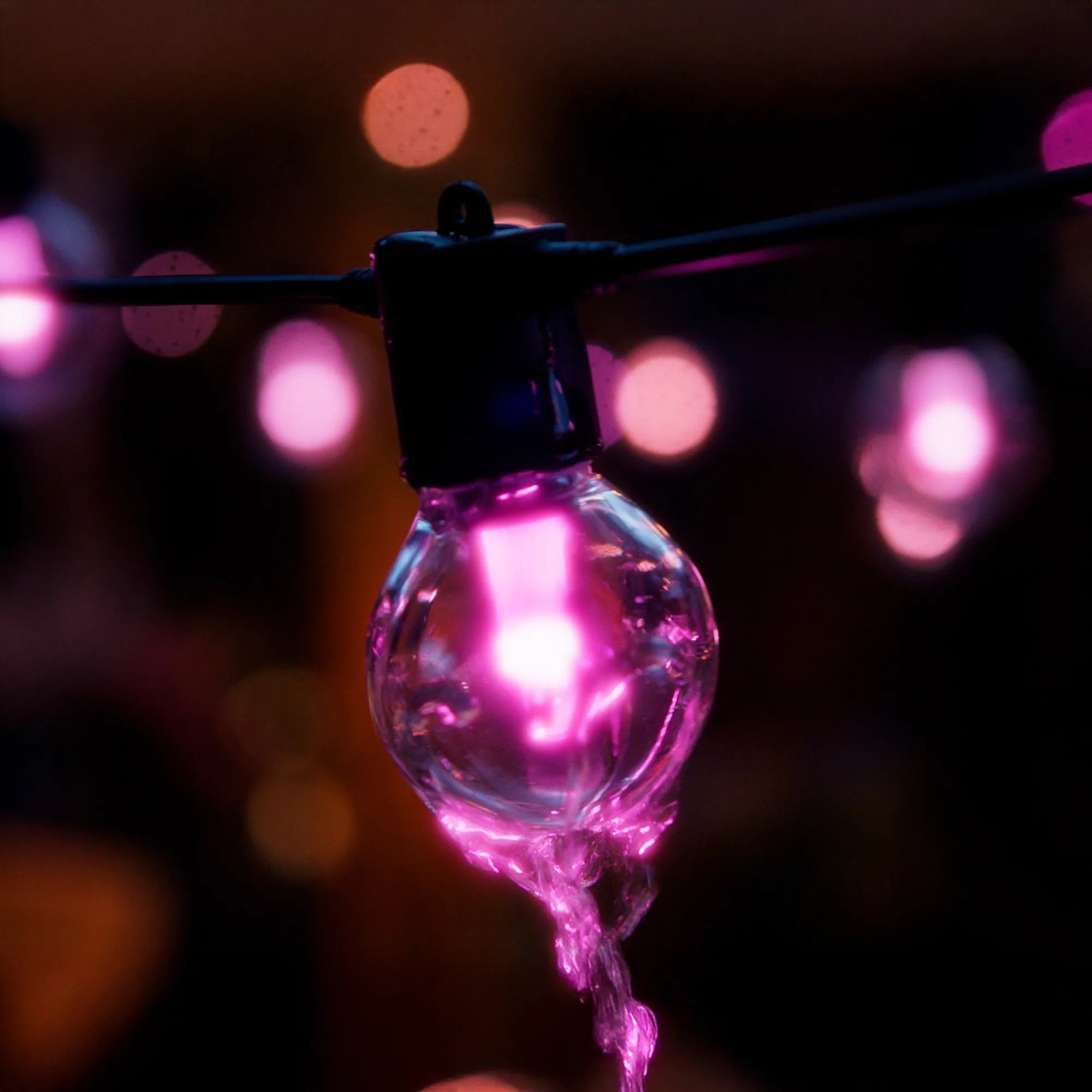 Nahaufnahme: Philips Hue Festavia Globe Lichterkette, pink leuchtend, für stimmungsvolle Außenbeleuchtung.