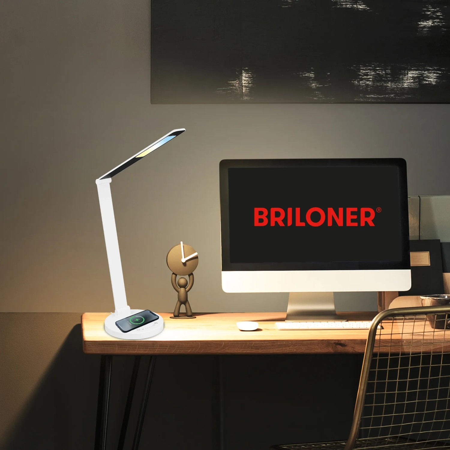 Weiße Brilo LED-Tischleuchte Cuma mit induktiver Ladefunktion und Touch-Dimmer auf einem Schreibtisch.