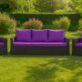 Violettes 3-Sitzer Gartensofa mit Sessel und Kissen aus Polyrattan im Garten.