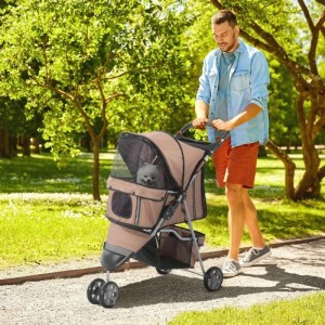 Mann schiebt beigen PawHut Hundewagen mit kleinem Hund im Park. Integrierter Becherhalter für Transportboxen.