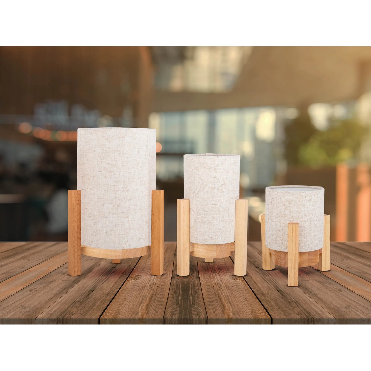 Drei Näve LED-Tischleuchten Madita aus Leinen und Holz in Natur auf einem Tisch.