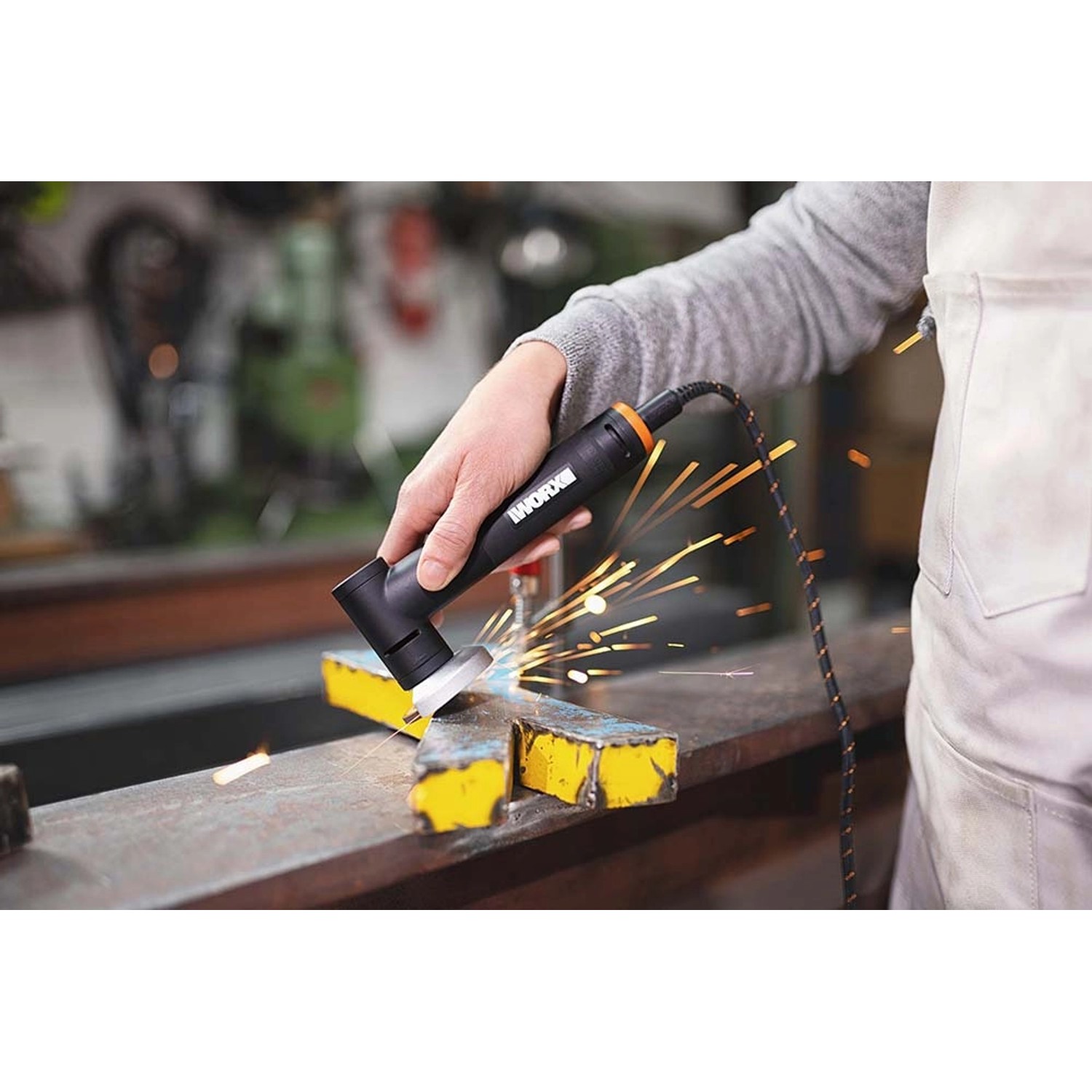 Worx MakerX Mini-Winkelschleifer WX741.9 im Einsatz beim Schleifen von Metall, Funken sprühen.