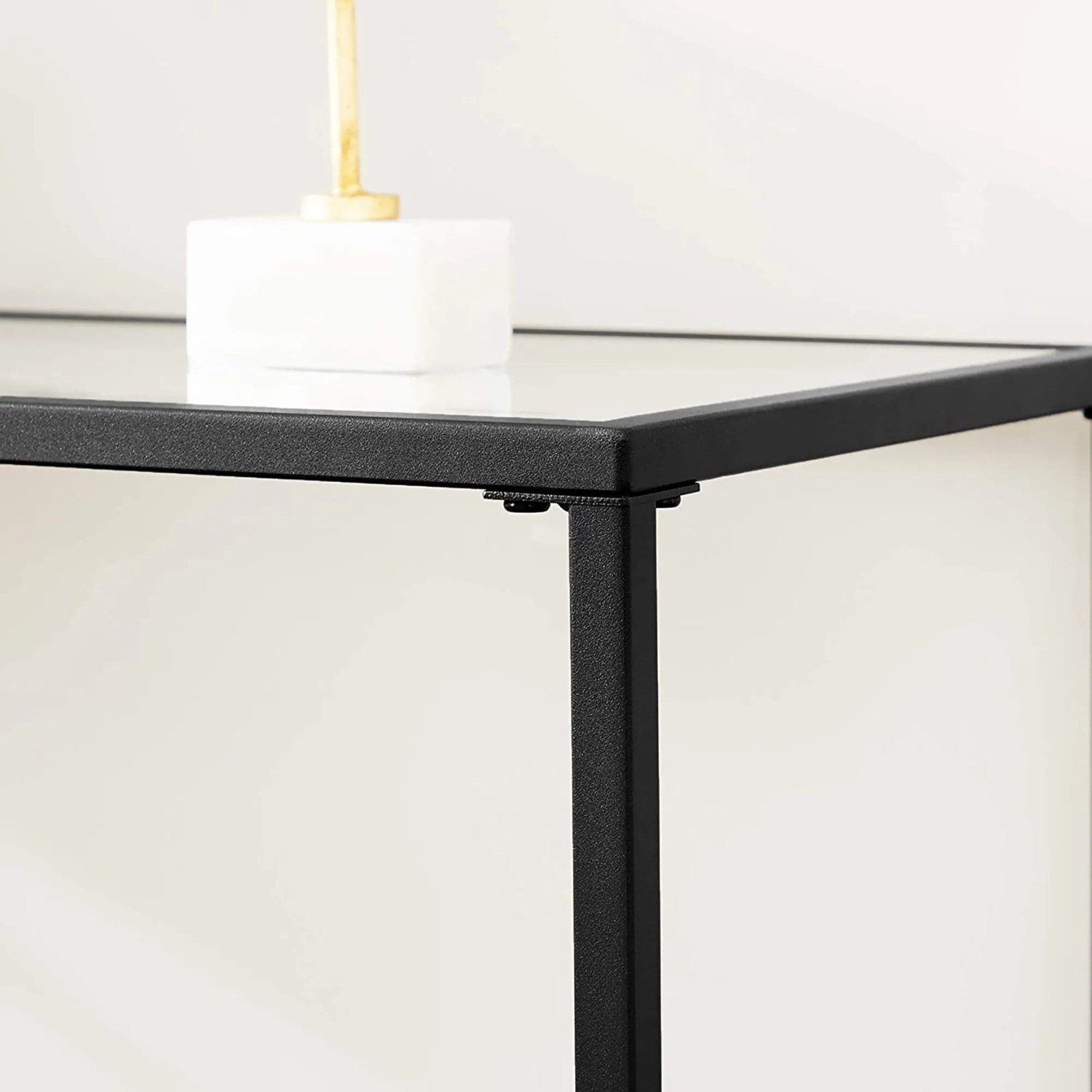 Detailansicht: Vasagle Konsolentisch mit schwarzem Metallgestell und transparenter Glasplatte.